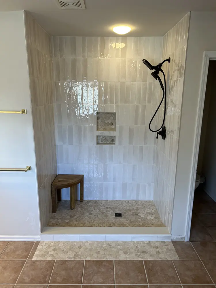 Tiled walk-in shower with a black handheld shower set
